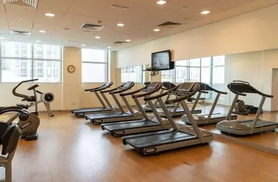 a gym with a row of tread machines in a room at The Lofts West Downtown - 2 Minutes Walk to Burj Khalifa-Dubai Mall 1BDR in Dubai