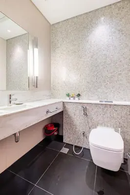 a bathroom with a white toilet and a mirror at Central Park Tower DIFC - 10 Minutes Walk to Metro - Spacious 1BDR in Dubai