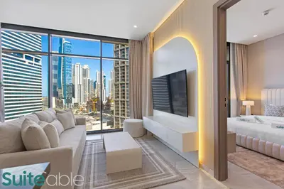 a living room with a couch and a large window at Luxury One Bedroom with Burj Khalifa View in Dubai