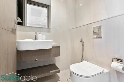 a white bathroom with a sink and a toilet at Luxury One Bedroom with Burj Khalifa View in Dubai