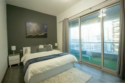 a bedroom with a bed and a large window at Marina Diamond 2 - Very Close to Metro - Cozy in Dubai