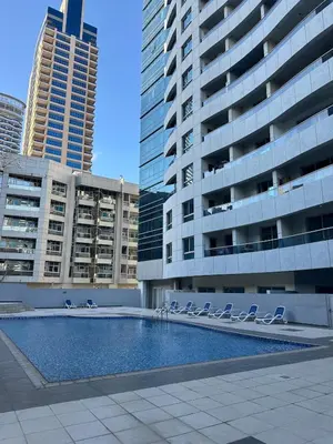 a swimming pool with lounge chairs in front of buildings at Marina Diamond 2 - Very Close to Metro - Cozy in Dubai