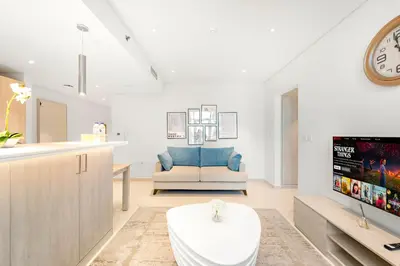 a living room with a couch and a tv at Luxury 1BR in Seven Palm with Beach Access in Dubai