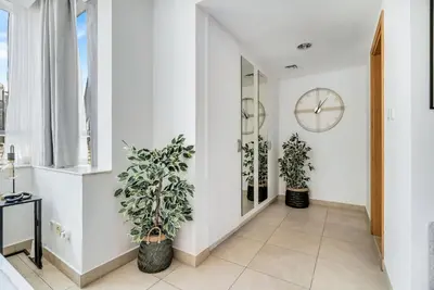 a hallway with potted plants and a clock on the wall at GuestReady - Elegant studio in JLT in Dubai