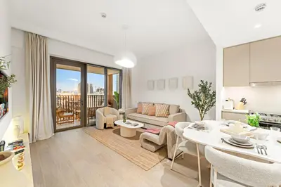 a living room with a couch and a table at Luxe 1BR in Orchid Creek with Balcony Pool & Gym in Dubai