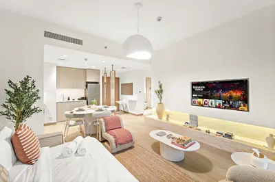 a living room with a couch and a table at Luxe 1BR in Orchid Creek with Balcony Pool & Gym in Dubai