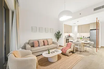 a living room with a couch and a table at Luxe 1BR in Orchid Creek with Balcony Pool & Gym in Dubai