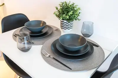 a table with two bowls and plates on it at SUNRISE HOMES - A Modern Studio near JBR Beach in Dubai