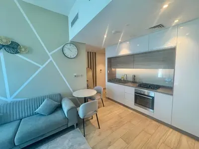 a living room with a couch and a table and a clock at Beautiful 1 bed apartment Marina I Sleeps 4 in Dubai