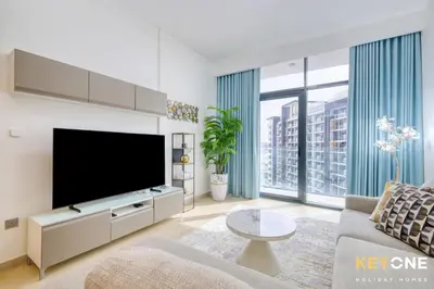 a living room with a large flat screen tv at Exquisite Living in Riviera One Bedroom in Dubai