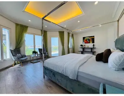 a large bedroom with a large bed with a ceiling at Palm villas in Dubai