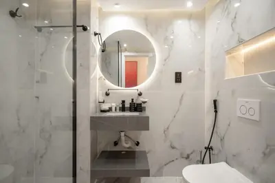 a bathroom with a shower and a sink and a mirror at Lux 5BR Marina Apt with Jacuzzi, Walk to Beach, Gym in Dubai
