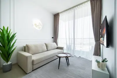 a living room with a couch and a window at SettlerHomes - Serene JVC 1BR With Modern Luxury in Dubai