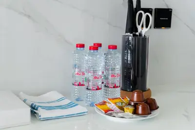 a group of water bottles and a vase with scissors at SettlerHomes - Serene JVC 1BR With Modern Luxury in Dubai