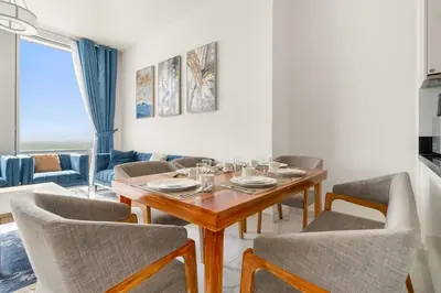 a dining room with a wooden table and chairs at 2BR Canal View Flat with Pool, Gym, 10 min Drive to Dubai Mall in Dubai