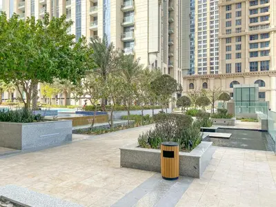 a park with benches and trees in a city at 2BR Canal View Flat with Pool, Gym, 10 min Drive to Dubai Mall in Dubai