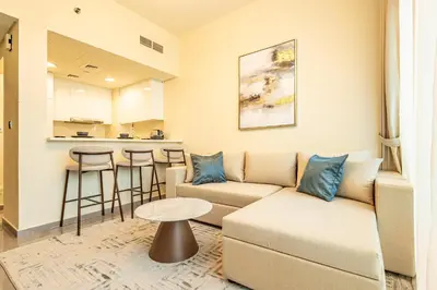 a living room with a couch and a table at Stylish 1BR Business Bay - Near Metro - Balcony with City Views in Dubai