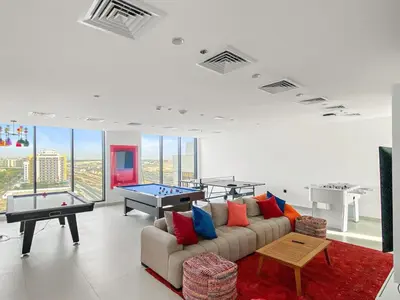 a living room with a couch and a pool table at Chic Dubai Studio with Balcony, Pool, Gym, Free Parking Near Expo Metro in Dubai
