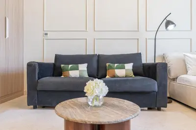 a living room with a blue couch and a table at Dubai Studio - Trendy Interiors - City Views in Dubai
