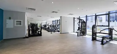 a gym with a row of treadmills and machines at Dubai Studio - Trendy Interiors - City Views in Dubai