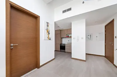 a hallway with a wooden door and a kitchen at Convenient 1BR apartment in Business Bay in Dubai