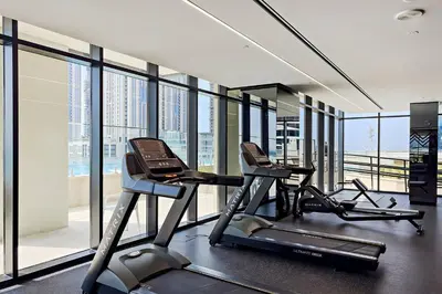a gym with two treadmills in a room with windows at Convenient 1BR apartment in Business Bay in Dubai
