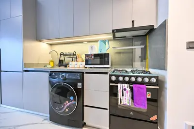 a kitchen with a stove and a washing machine at Charming Studio in Meydan by Deleguest in Dubai