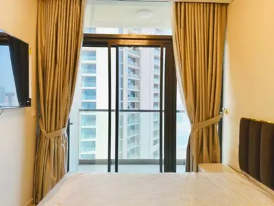 a bedroom with a bed and a large window at ايكون ستي 2BEd in Dubai