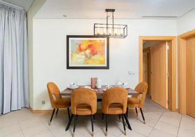 a dining room with a table and chairs at Bespoke Holiday Homes - 2BR Apartment with Riva Beach Club Access, Al Nabat in Dubai