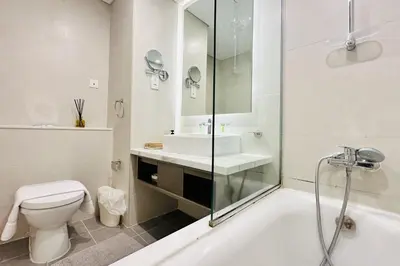 a bathroom with a tub and a toilet and a sink at Vserve - Stylish specious - 1 Bedroom with Canal View in Dubai