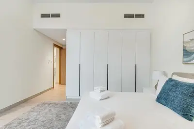 a white bedroom with a bed with towels on it at Dubai Luxury 4BR Villa in Murooj Al Furjan in Dubai