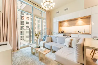 a living room with a couch and a table at Near Dubai Marina Canal 2BR with Pool and City Views Balcony, Studio One, Dubai Marina by Deluxe Holiday Homes in Dubai