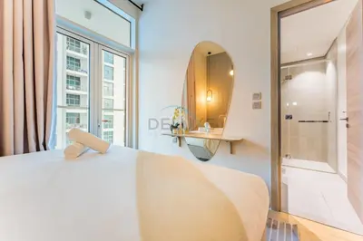 a bedroom with a white bed and a large window at Near Dubai Marina Canal 2BR with Pool and City Views Balcony, Studio One, Dubai Marina by Deluxe Holiday Homes in Dubai