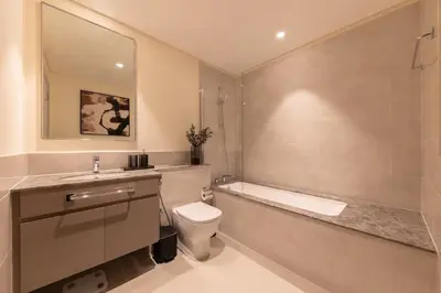 a bathroom with a tub and a toilet and a sink at Royal 4BR Burj Khalifa View Dubai Mall in Dubai