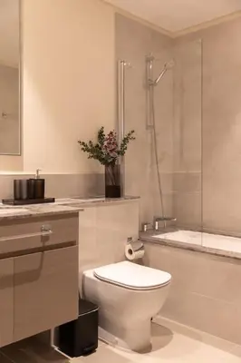 a white bathroom with a toilet and a shower at Royal 4BR Burj Khalifa View Dubai Mall in Dubai