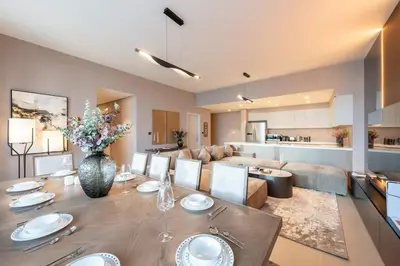 a dining room and living room with a table and a couch at Royal 4BR Burj Khalifa View Dubai Mall in Dubai