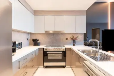 a kitchen with white cabinets and a stove and a sink at Royal 4BR Burj Khalifa View Dubai Mall in Dubai