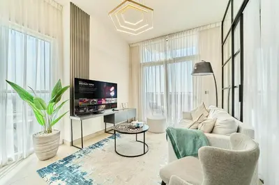 a living room with a couch and a tv at Stylish 2BR Apartment Steps from Dubai Hills Mall in Dubai