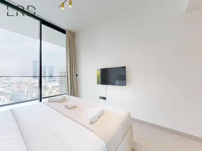 a bedroom with a bed and a large window at Brand New and Modern Smart Home 1BR in Dubai