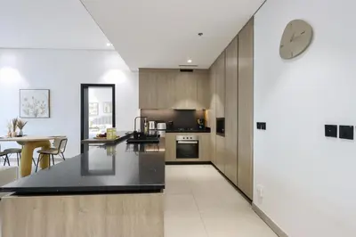 a kitchen with a counter and a clock on the wall at Livbnb-Stylish and Spacious 1BR Apartment with Private Balcony in Dubai