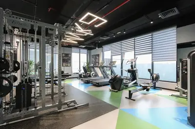 a gym with treadmills and cardio equipment and windows at Livbnb-Stylish and Spacious 1BR Apartment with Private Balcony in Dubai