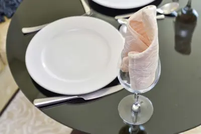 a table with a plate and a wine glass with a napkin at Luxury Living At The Address Dubai Marina! in Dubai