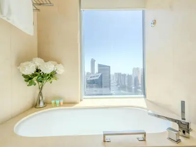 a bath tub with a vase of flowers and a window at Luxury Living At The Address Dubai Marina! in Dubai
