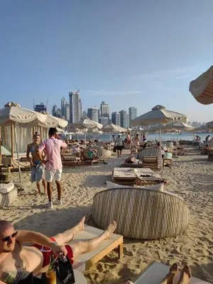 a group of people laying on the beach at Seven Hotel Palm jumeirah in Dubai