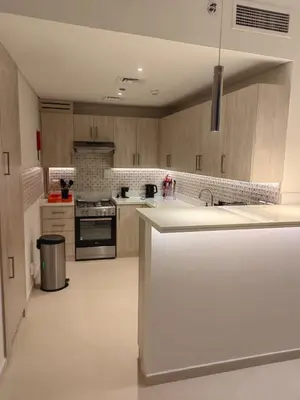 a kitchen with wooden cabinets and a white counter top at Seven Hotel Palm jumeirah in Dubai