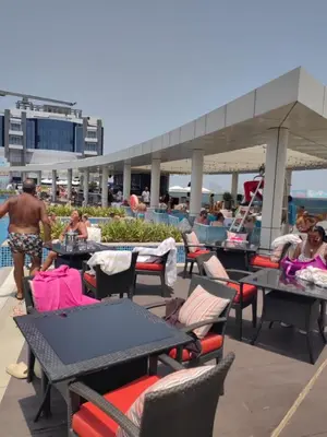 a group of tables and chairs next to a pool at Seven Hotel Palm jumeirah in Dubai