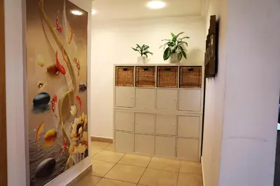 a hallway with a closet with plants on the wall at Nice Place in Dubai