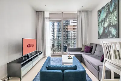 a living room with a couch and a tv at GuestReady - Marina Gate Studio Suite in Dubai