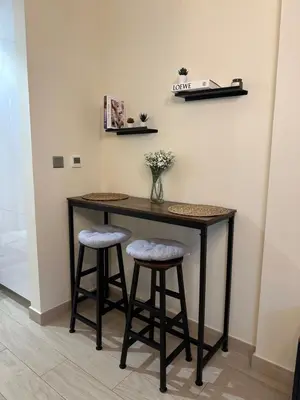 a table with two stools in a room at Azizi Riviera 44 in Dubai