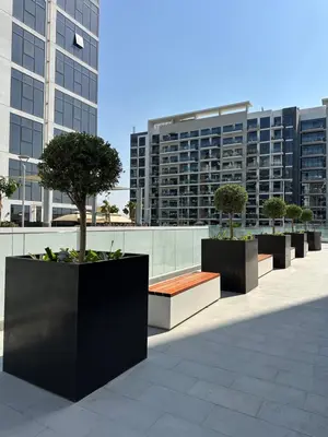 a row of benches with trees on top of a building at Azizi Riviera 44 in Dubai